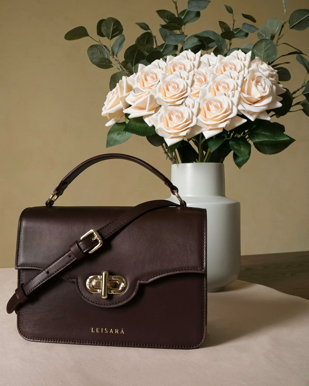 Leather bag and sculptural objects in a neutral interior